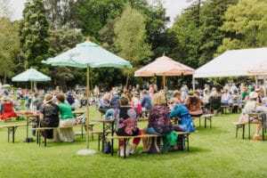 People enjoying outdoor event under umbrellas.