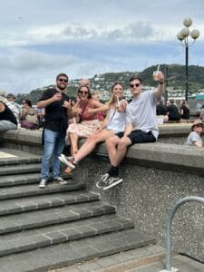 Group enjoying drinks by seaside steps