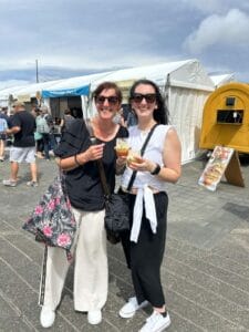 Two women enjoying drinks at an outdoor event.