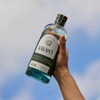 Bottle of Kākāpō Gin held up to the sky