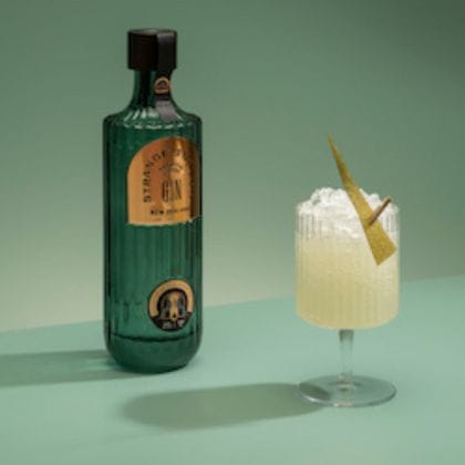 Green gin bottle and cocktail glass with garnish.