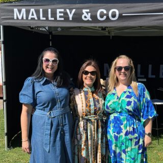 Three ladies standing in front of the Malley & Co marquee at Gindulgence Christchurch