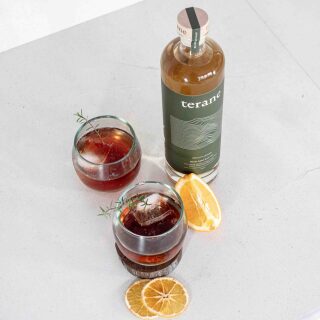 Pohutakawa cocktail with bottle of gin and orange garnishes.